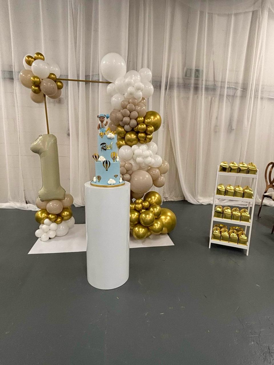 Gold and white balloon setup for a first birthday party