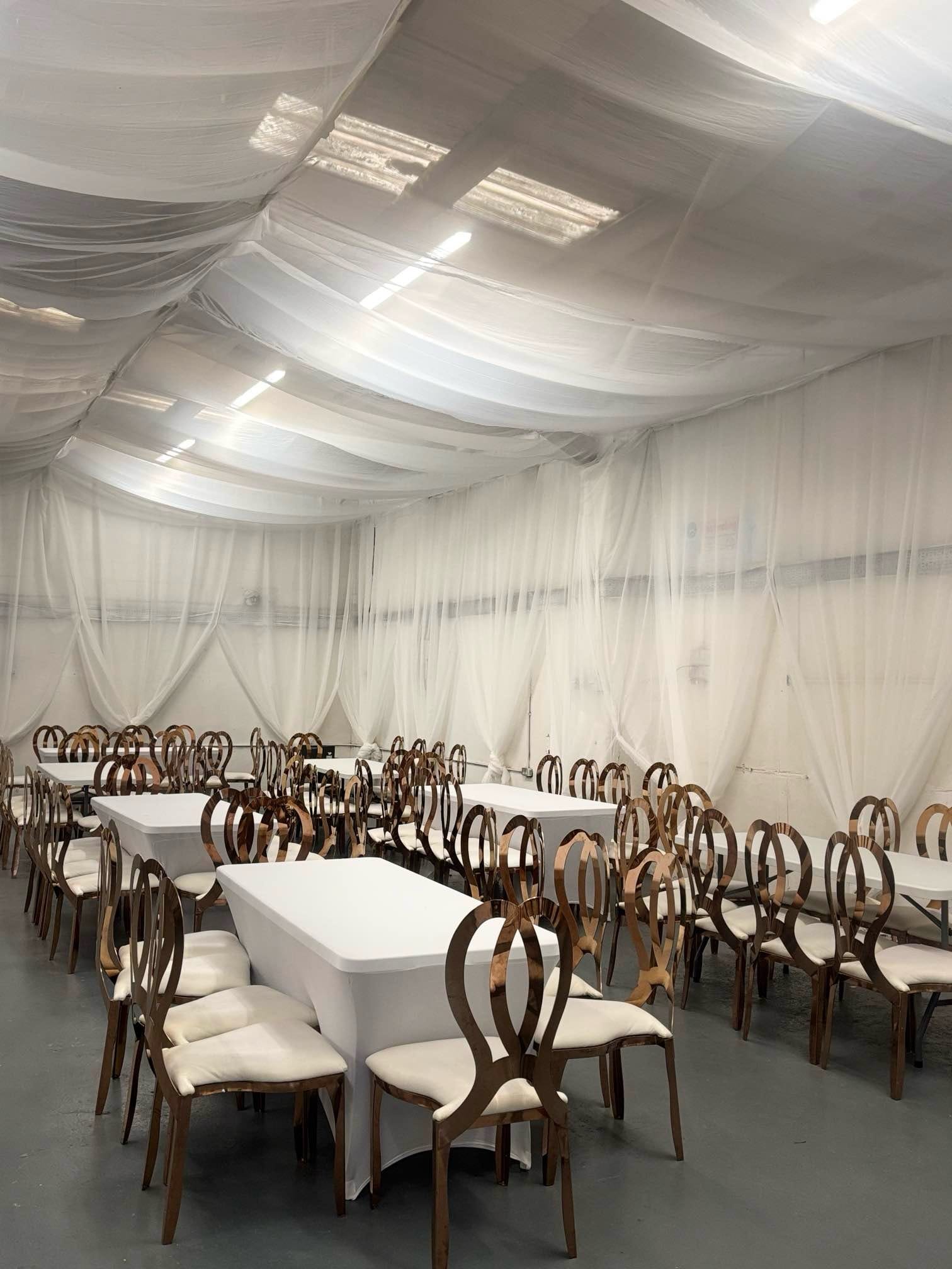 Majestic Divine Events venue prepared with draped white ceiling and tables